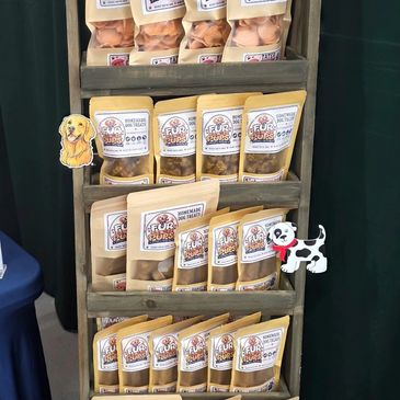 Display of packaged dog treats on a wooden stand.