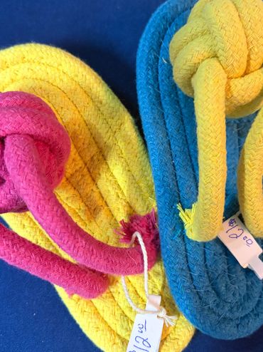 Colorful woven slippers with price tags.