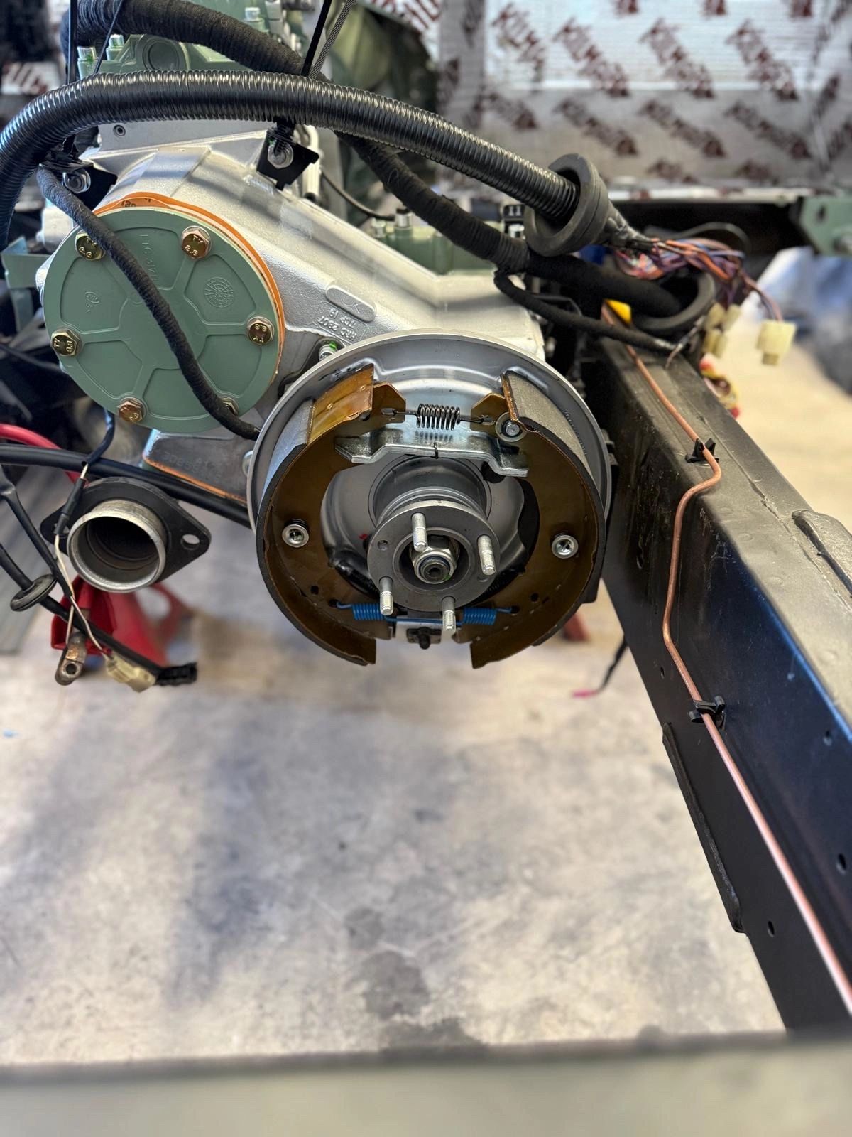 Close-up of a vehicle's drum brake assembly installed on a metal frame.