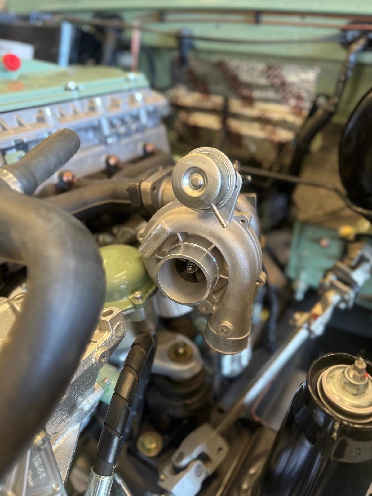 Close-up of a turbocharger installed in an engine bay.