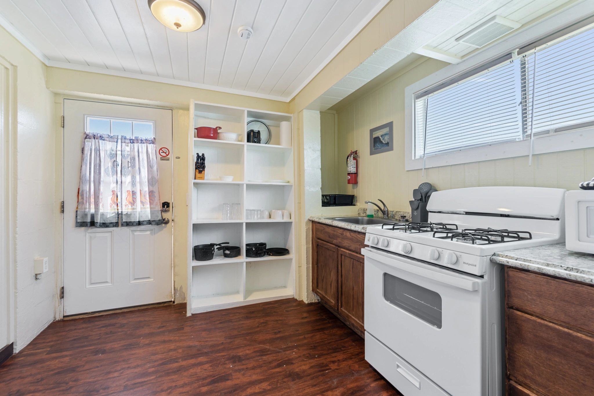 A kitchen with white appliances, wood cabinets, and granite countertops.