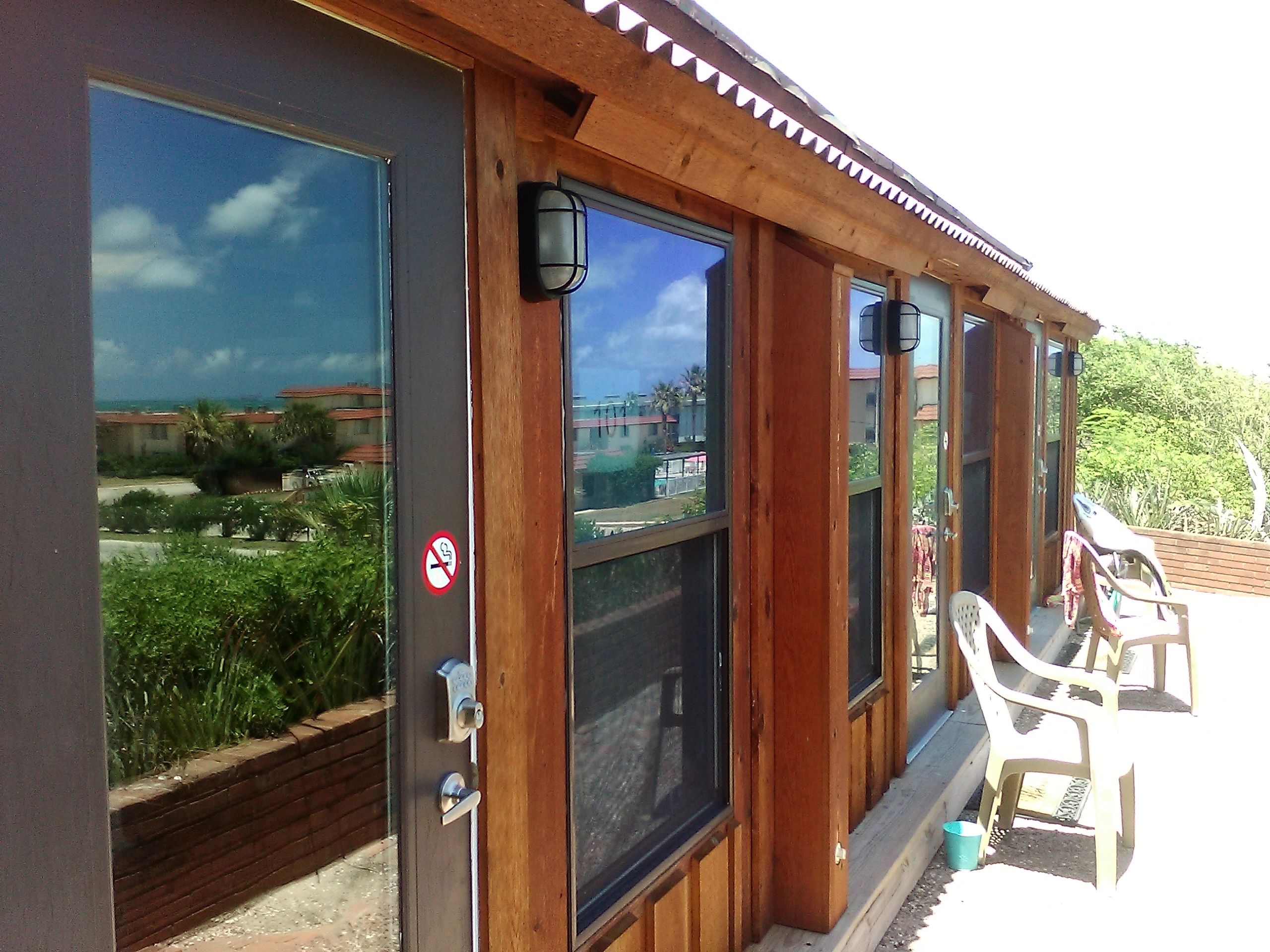 A wooden building with glass doors and outdoor seating area