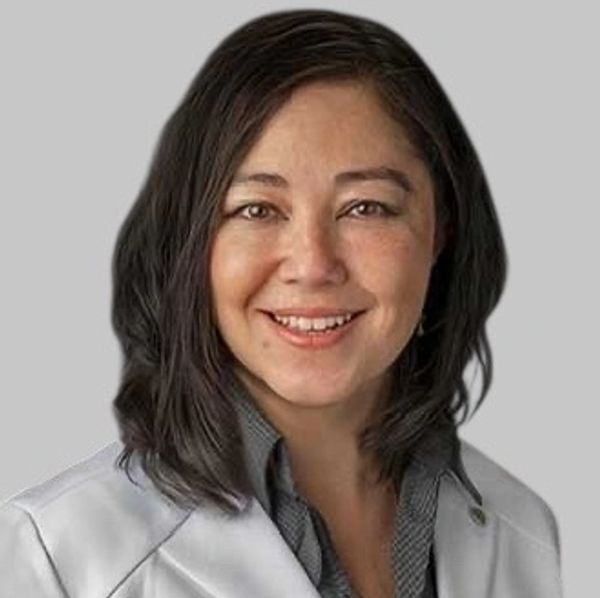 Smiling woman with dark hair in business attire.