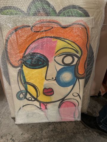 Colorful abstract face painting wrapped in bubble wrap.