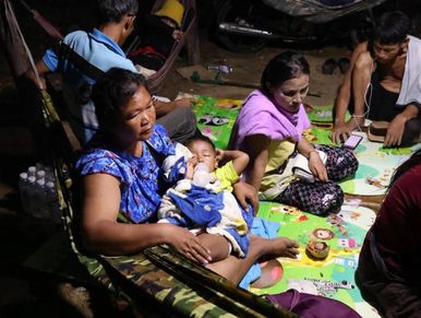 Villagers in Prey Chan, Cambodia sit under a tent near the barbed wire fence at the disputed border.