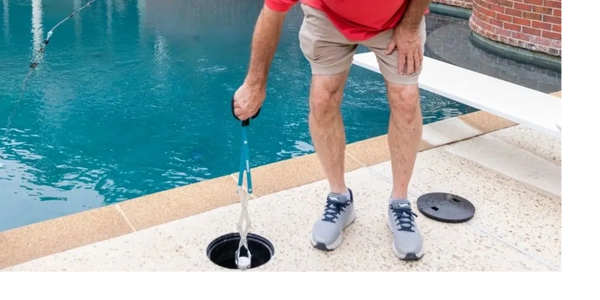 a man using skimmer cleaning tool
