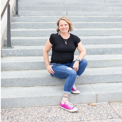 Michelle Risser, LISW-S, maternal mental health and trauma therapist sits on steps. 