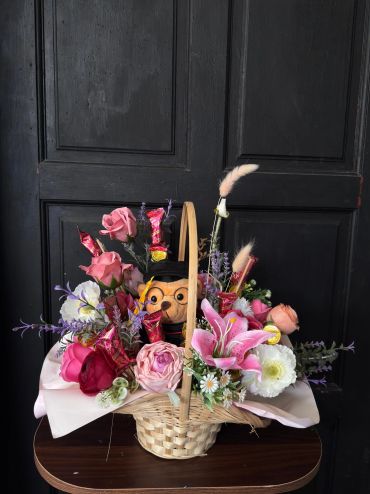 Decorative basket with flowers and a toy owl.