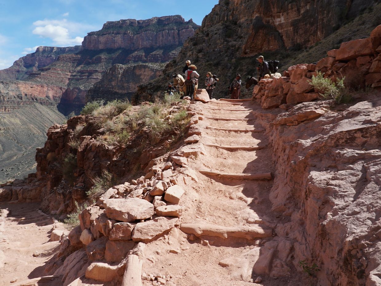 A steep row of rugged stairs, with Cara on horseback with West, Kelcy, John and Mike at the top 