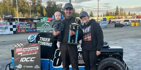 Happy racing family celebrates a trophy win at the track.