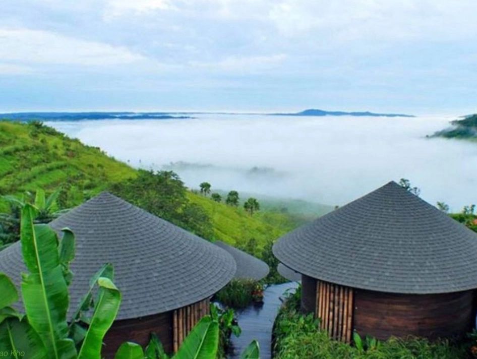 Luxurious green mountaintop resort in Thailand overlooking the valley and clouds.