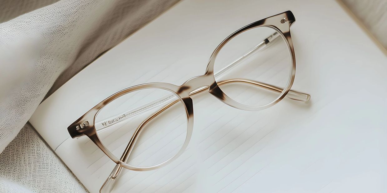 Transparent eyeglasses resting on an open lined notebook.