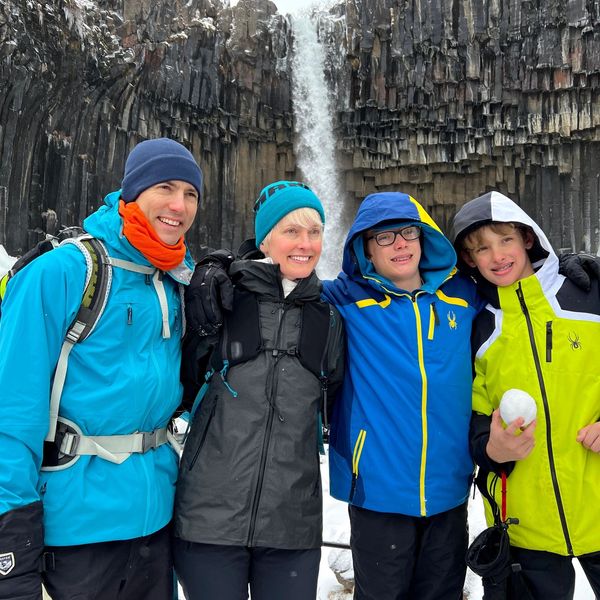 Family of four in front a basalt formations and an icy waterfall during a student tour in Iceland.