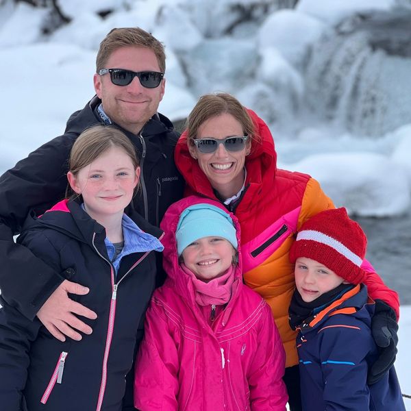 Family of five in front of an icy waterfall during a student trip to Iceland.