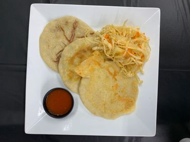 Cheese, bean, and pork pupusa, with a cabbage slaw, and a tomato based dipping sauce.