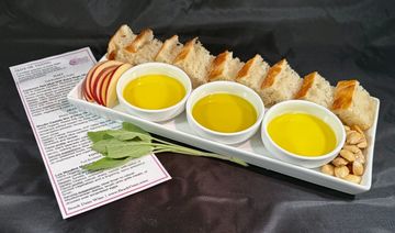 Bread and olive oil tasting plate with apples and nuts.