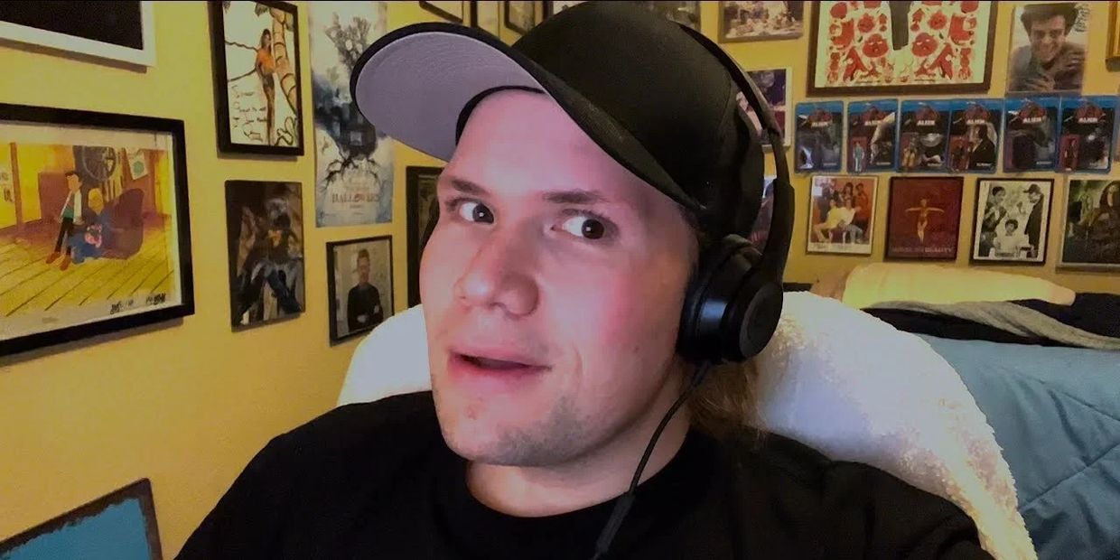 Young man with headphones in a room filled with framed posters.