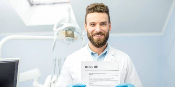 Dentist Holding his resume in front of a dentist's chair