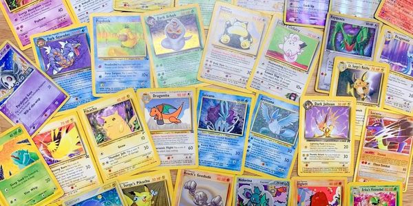 A collection of various vintage Pokémon trading cards spread out on a wooden surface.