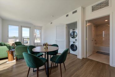 Modern dining and living area with laundry and bathroom.