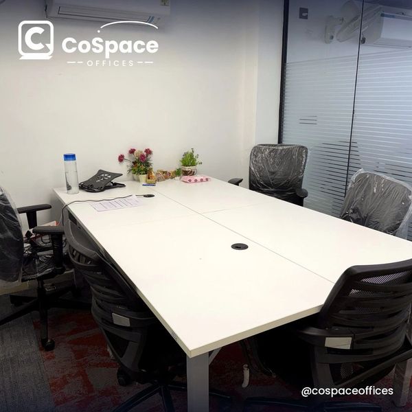 Modern meeting room with white table and black chairs.