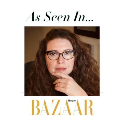 Redhead Sexual Intuitive®️ Susanna Brisk sitting with one hand on her chin with Harper’s Bazaar logo 
