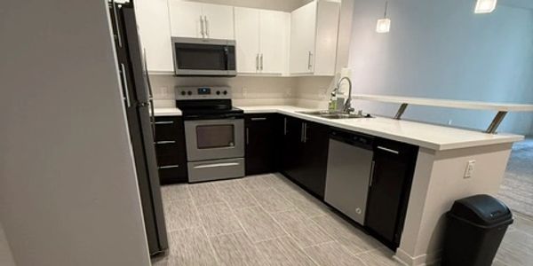 Modern kitchen with stainless steel appliances and two-tone cabinetry.