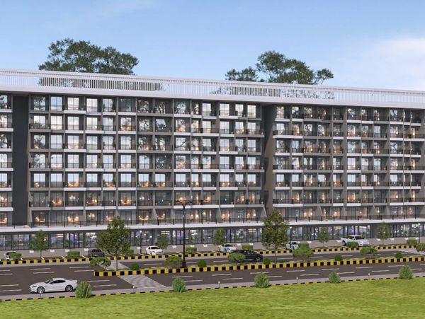 Modern multi-story residential building with balconies and greenery in front.