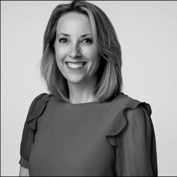 Smiling woman in a professional black-and-white portrait.