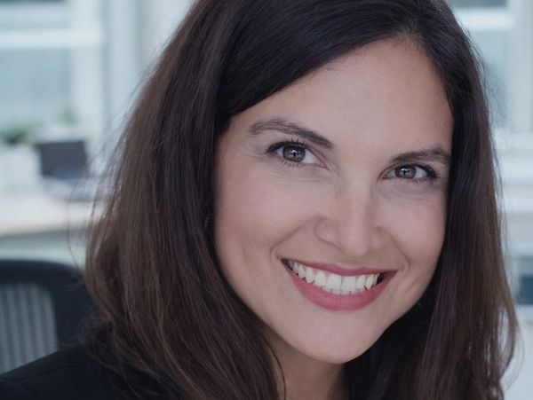 Smiling woman with dark hair in a professional setting.