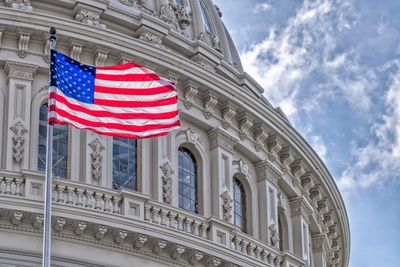 Image of a government building - round or dome shaped with American Flag flying in front