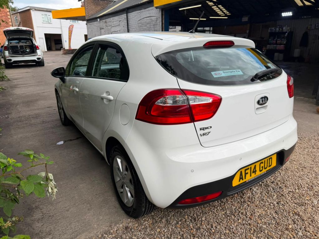 White Kia Rio VR7 parked outside a garage.