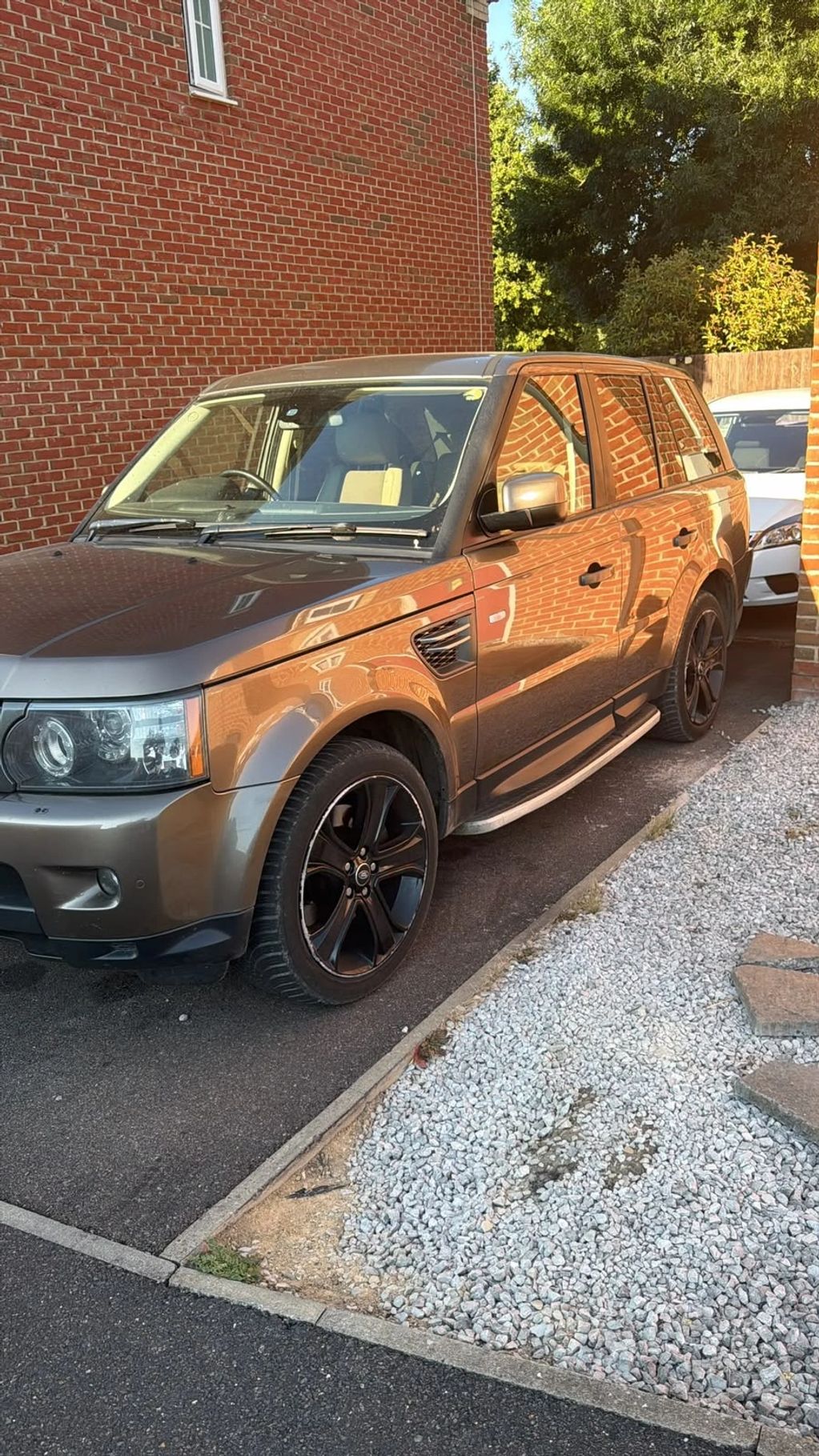 Gray SUV parked near a brick building with reflective windows.