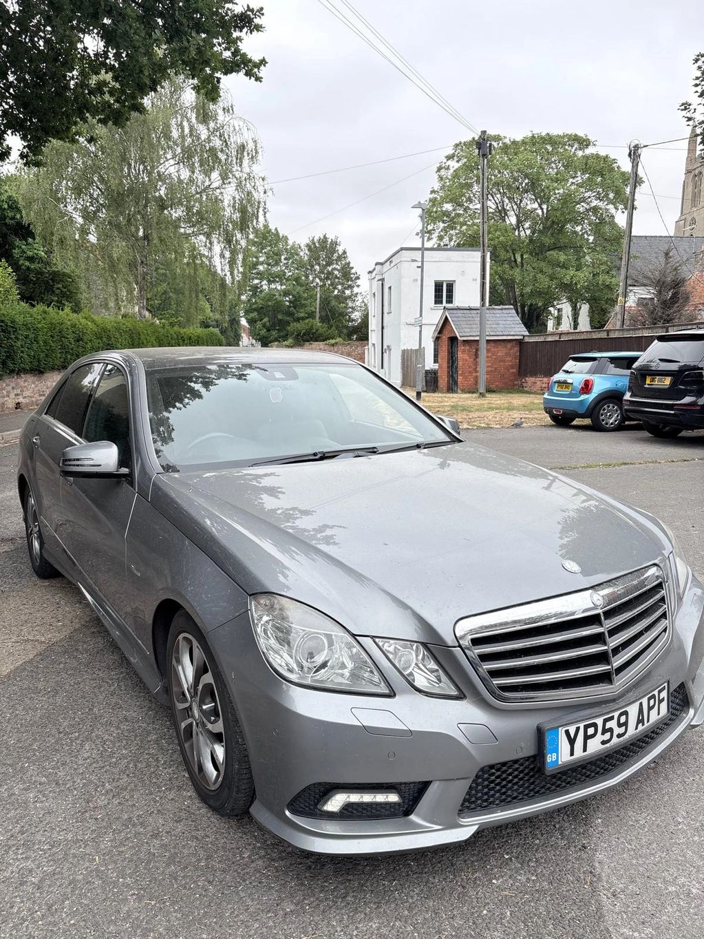 Silver Mercedes-Benz parked on a suburban street.