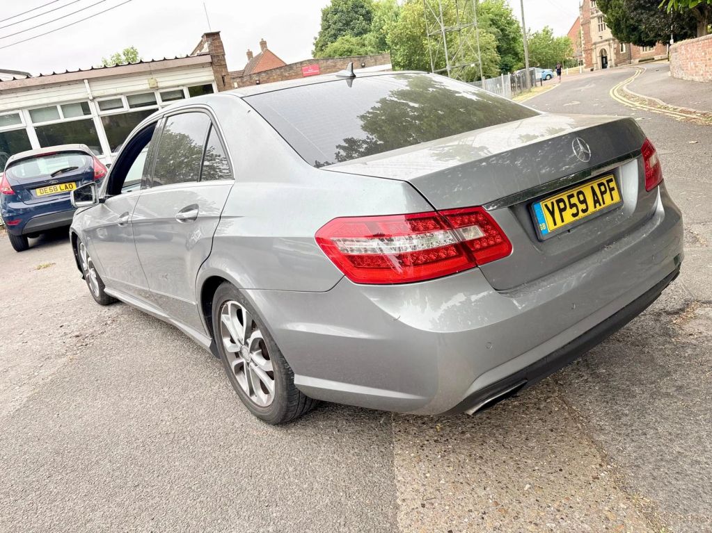 Silver Mercedes sedan parked on the street.