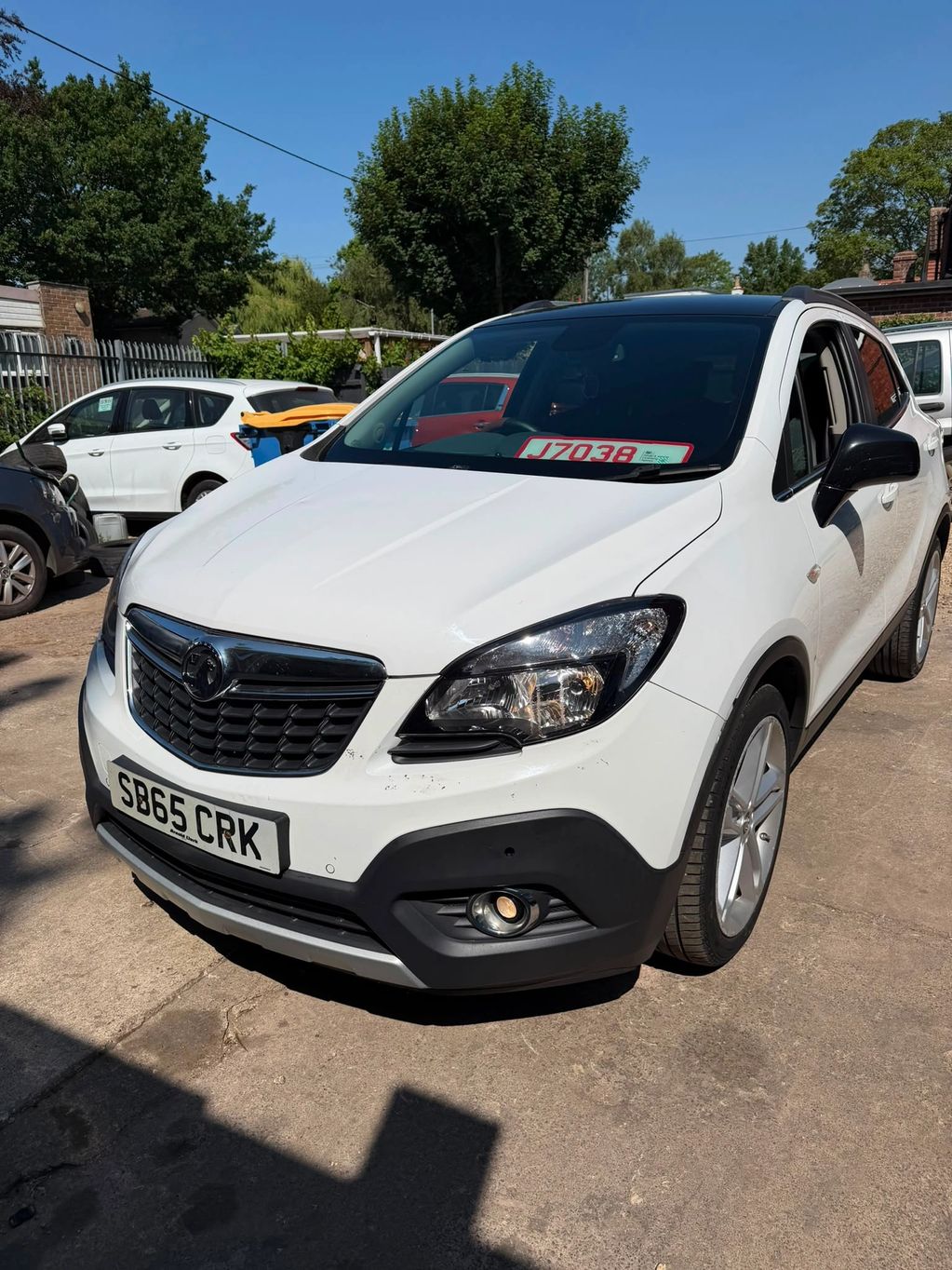 White Vauxhall SUV parked outside on a sunny day.