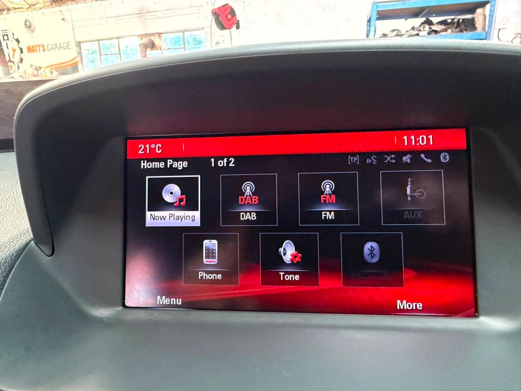 Car dashboard infotainment screen showing radio and phone options.