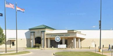 Front view of a government building with flags and entrance canopy.
