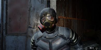 Person in tactical gear and gas mask indoors.