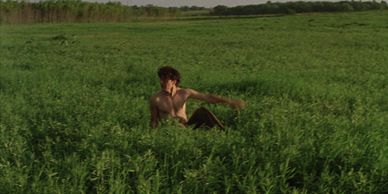 A person sitting in a green field.
