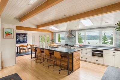 kitchen and living room remodel eat at island wood island ceiling beams sky lights wood flooring gray subway tile back splash white ship lap ceiling 