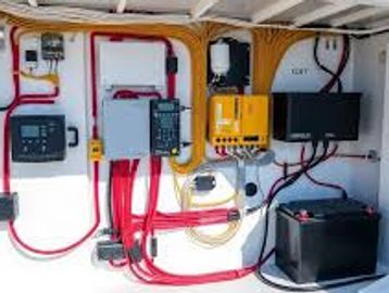 Electrical control panel with wires and devices organized on a wall.