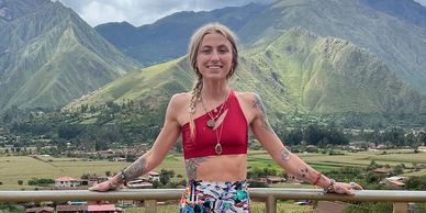 Happy woman posing in front of mountainous landscape.