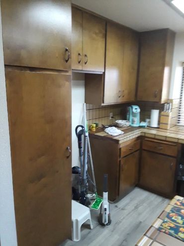 Cozy kitchen corner with wooden cabinets and cleaning supplies.