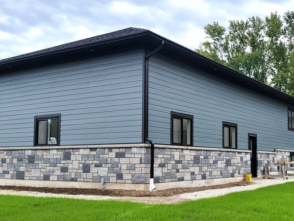 Custom built home with blue hardi siding and beautiful windows installed by a trusted builder.