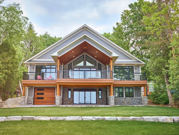 Beautiful custom built cottage home with stunning windows and modern siding with a custom deck.
