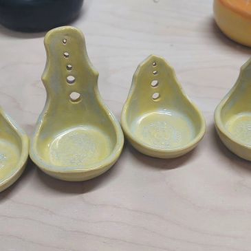 Yellow ceramic spoon rests with holes.