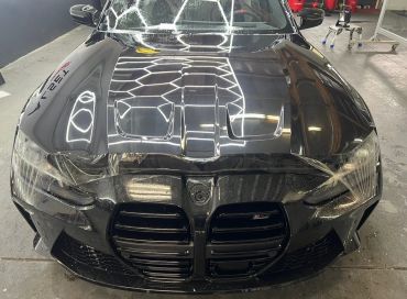 Front view of a sleek black BMW car with distinctive grille design.