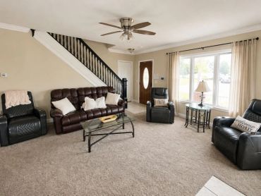 Cozy living room with leather seating and large window.