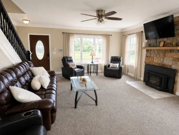 Cozy living room with leather furniture and a stone fireplace.